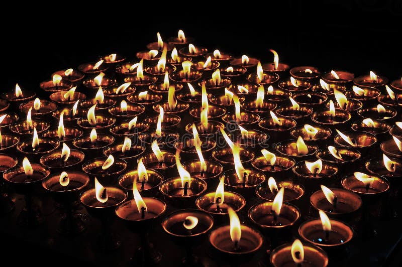 Butter lamps with flames. Near Bodhnath stupa in Gandan Monastery of Gelug Sect, Tibetan buddhism, lhasa stock photography