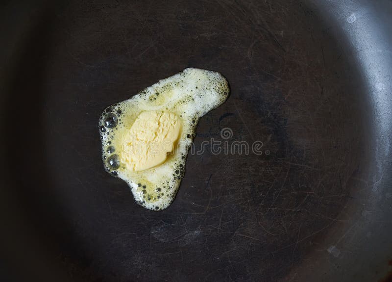 Butter Pat Melting on a Black Cast Iron Frying Pan Stock Image Image
