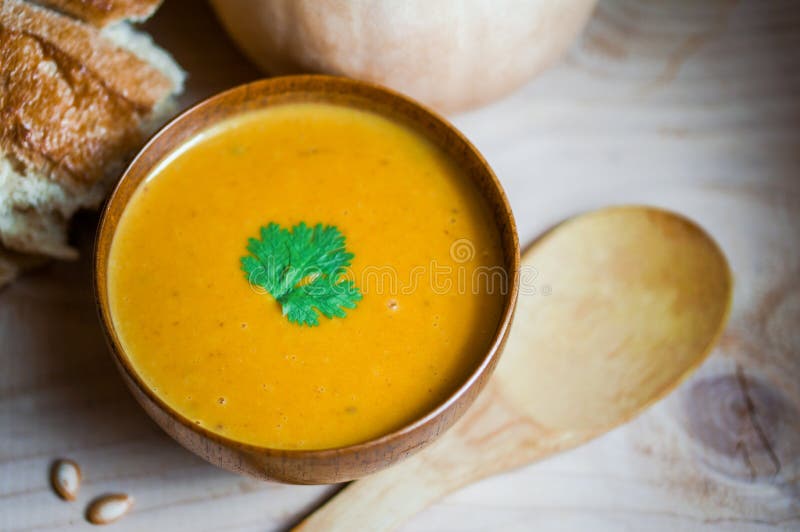 Butternut kabaczka polewka z domowej roboty chlebem na drewnianym tle obraz stock Butternut kabaczka polewka z domowej roboty chlebem na drewnianym tle obraz stock