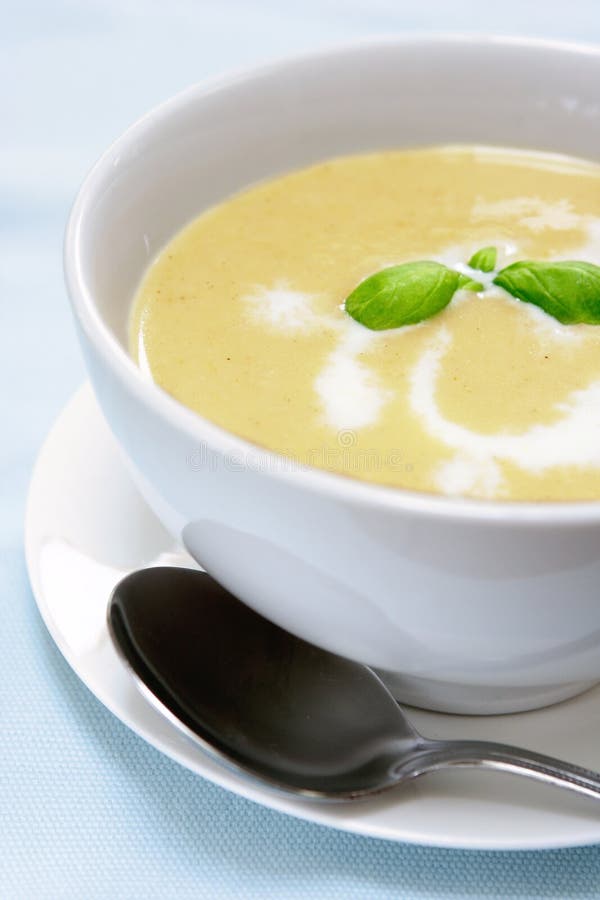 Butternut zuppa di patate e servite con la panna e il rametto di basilico fresco.