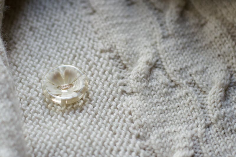 Button & white detail of woven handicraft knit sweater