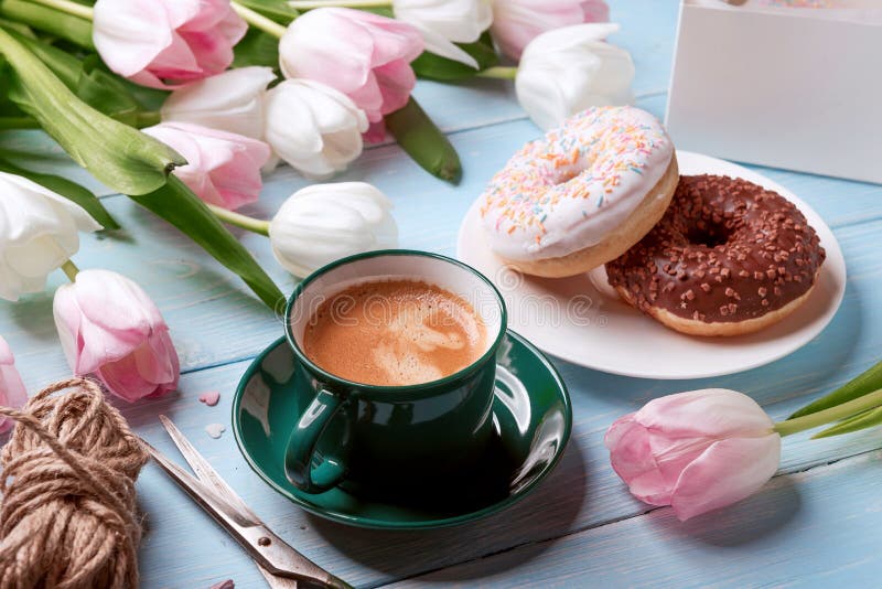 Butées toriques, café et tulipes sur un fond en bois bleu image stock Butées toriques, café et tulipes sur un fond en bois bleu image stock