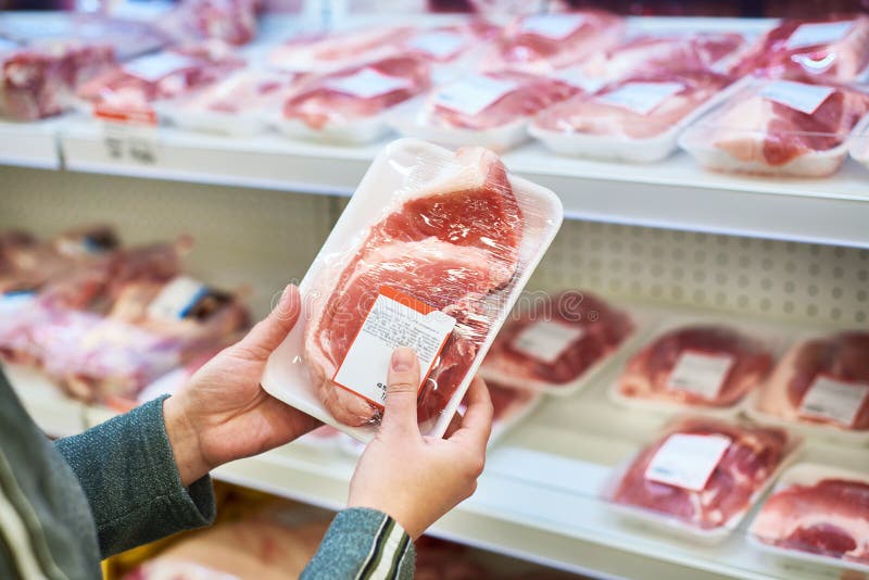 Buyer hands with pork meat at grocery