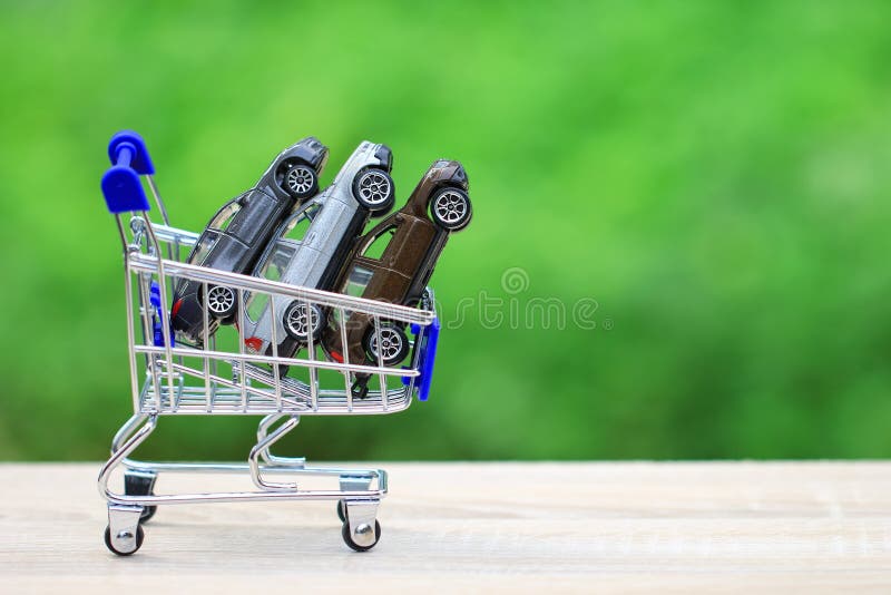Buying new car concept, Miniature car model in Shopping cart on nature green background stock photos Buying new car concept, Miniature car model in Shopping cart on nature green background stock photos