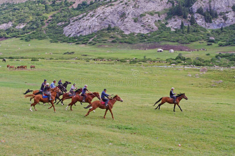 National game in Kyrgyzstan - Buzkashi. Horse riders are fighting on dead sheep. Kyrgyzs horse riders in national park Beshtash in Talas region in Kyrgyzstan. National game in Kyrgyzstan - Buzkashi. Horse riders are fighting on dead sheep. Kyrgyzs horse riders in national park Beshtash in Talas region in Kyrgyzstan.