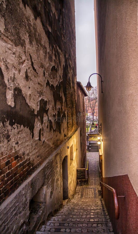 Bydgoszcz Polen, färgglad fasad av den gamla historiska hyreshusen den mycket smala gatan och lampan tänder på trappa fotografering för bildbyråer Bydgoszcz Polen, färgglad fasad av den gamla historiska hyreshusen den mycket smala gatan och lampan tänder på trappa fotografering för bildbyråer