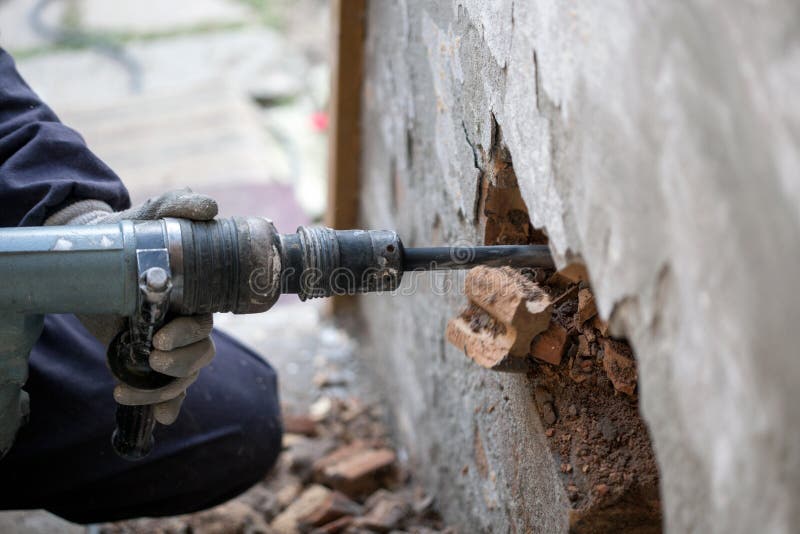 Byggmästarearbetare med utrustning för drillborr för pneumatisk hammare som bryter br
