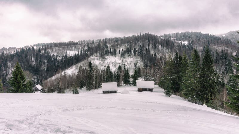 Byhuts och gröngrynd i snöbergen fotografering för bildbyråer Byhuts och gröngrynd i snöbergen fotografering för bildbyråer
