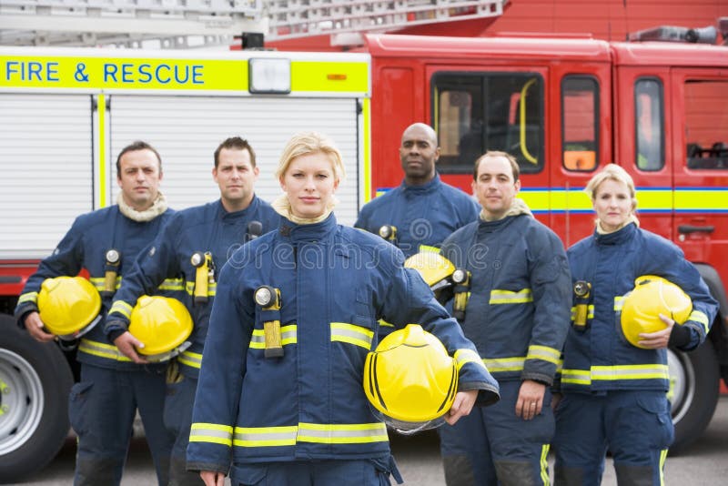 Portrait of a group of firefighters by a fire engine. Portrait of a group of firefighters by a fire engine