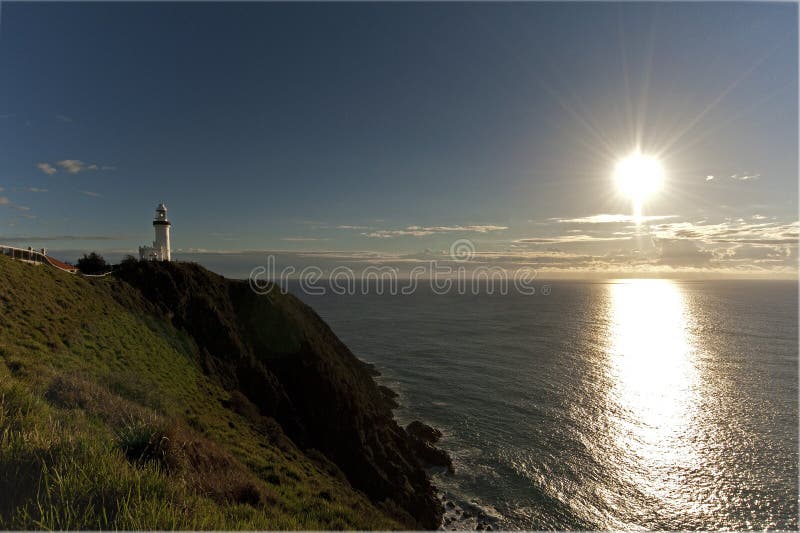 Byron Bay lighthouse in the distance with the sun shining on the ocean. Byron Bay lighthouse in the distance with the sun shining on the ocean.