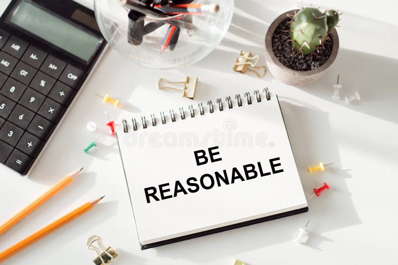 Be reasonable - text written on notebook on ofiice table. Be reasonable - text written on notebook on ofiice table.