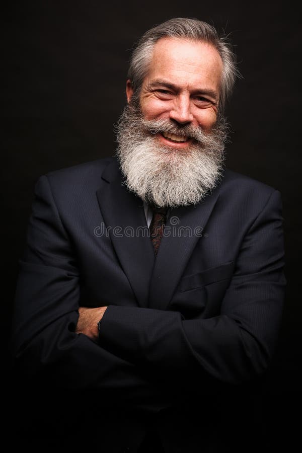 Bärande dräkt för mogen manlig modell med den gråa frisyren och skägget arkivfoto Bärande dräkt för mogen manlig modell med den gråa frisyren och skägget arkivfoto