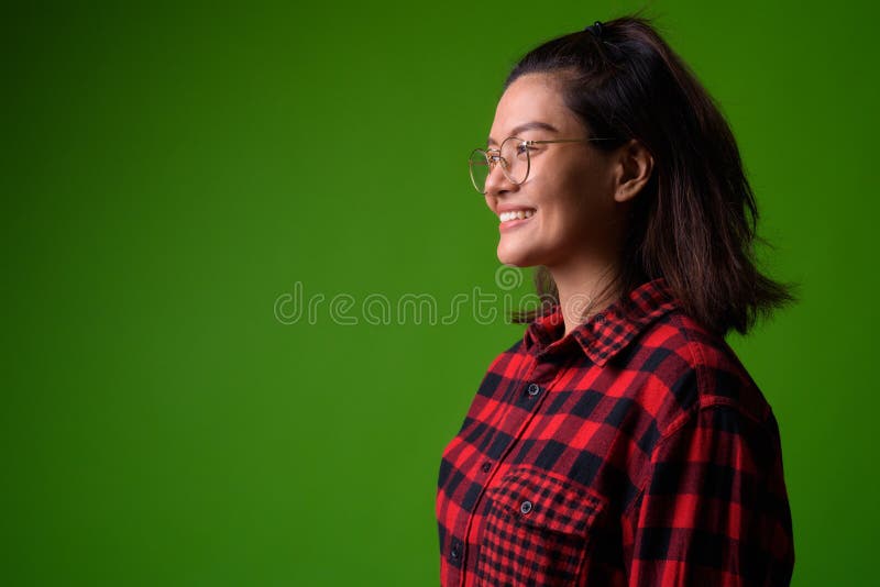 Bärande glasögon för ung härlig asiatisk hipsterkvinna och röd rutig skjorta royaltyfri fotografi Bärande glasögon för ung härlig asiatisk hipsterkvinna och röd rutig skjorta royaltyfri fotografi
