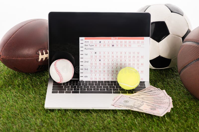 Laptop near sports balls and betting list on green grass isolated on white, sports betting concept. Laptop near sports balls and betting list on green grass isolated on white, sports betting concept