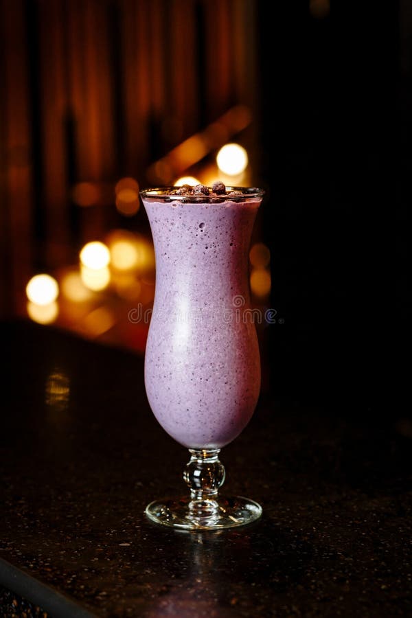 Bärsmoothie med djupfrysta bär i ett exponeringsglas på ett ben arkivfoto Bärsmoothie med djupfrysta bär i ett exponeringsglas på ett ben arkivfoto