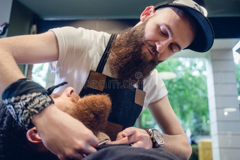 Bärtiger junger Mann bereit zum Rasieren im Friseursalon einer Fähigkeit lizenzfreie stockfotografie Bärtiger junger Mann bereit zum Rasieren im Friseursalon einer Fähigkeit lizenzfreie stockfotografie