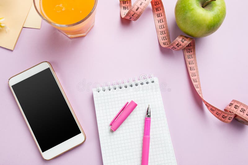 Bästa sikt av det gröna äpplet som mäter bandet, mobiltelefonen, pennan och den öppna anteckningsboken avkoppling för pilates för royaltyfria foton Bästa sikt av det gröna äpplet som mäter bandet, mobiltelefonen, pennan och den öppna anteckningsboken avkoppling för pilates för royaltyfria foton