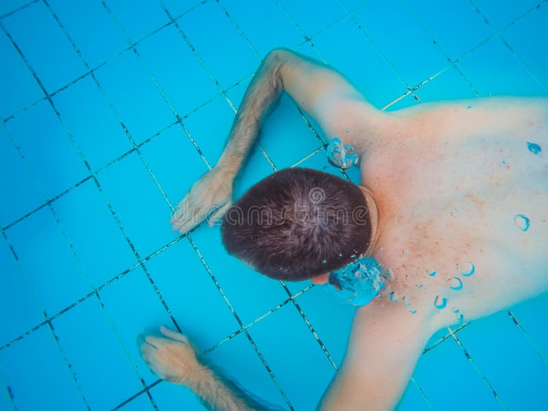 Bästa sikt av ungt stiligt dyka för man som är undervattens- i en simning arkivfoto Bästa sikt av ungt stiligt dyka för man som är undervattens- i en simning arkivfoto