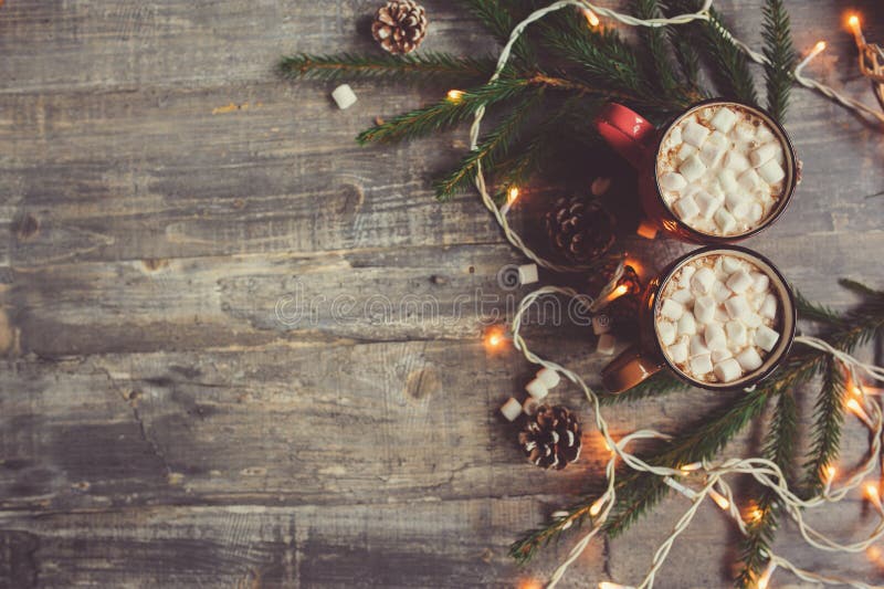 Bästa sikt av varm kakao med marshmallower på den lantliga trätabellen med julljus