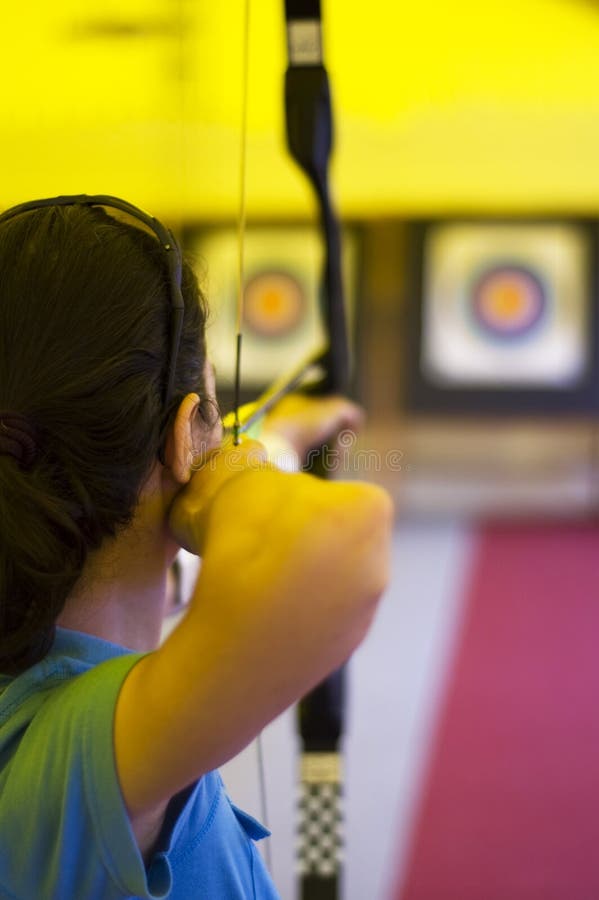 Girl aiming her arrow to the bull's eye. Girl aiming her arrow to the bull's eye