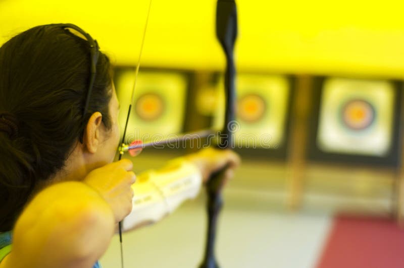 Girl aiming her arrow to the bull's eye. Girl aiming her arrow to the bull's eye