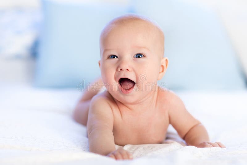 Bébé dans la couche-culotte dans le lit Nouveau-né à la maison photos stock Bébé dans la couche-culotte dans le lit Nouveau-né à la maison photos stock
