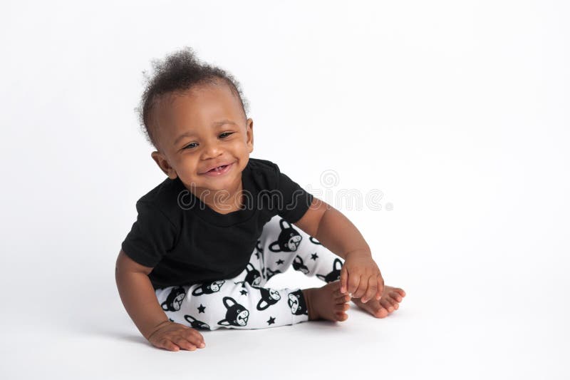 A smiling, nine month old, baby boy sitting on a white, seamless background. A smiling, nine month old, baby boy sitting on a white, seamless background.