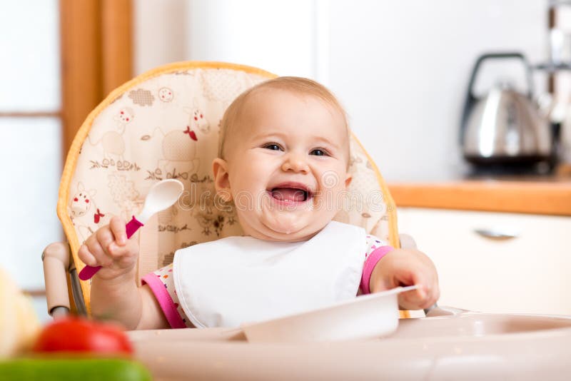 Bébé souriant mange dans la cuisine image libre de droits