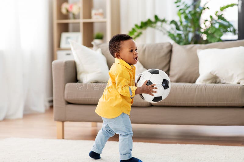 Bébé garçon d'afro-américain jouant avec du ballon de football photographie stock libre de droits Bébé garçon d'afro-américain jouant avec du ballon de football photographie stock libre de droits