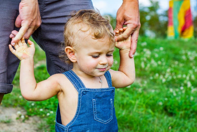 Bébé garçon en parc Faites confiance aux mains de famille du fils et du père d'enfant images stock Bébé garçon en parc Faites confiance aux mains de famille du fils et du père d'enfant images stock