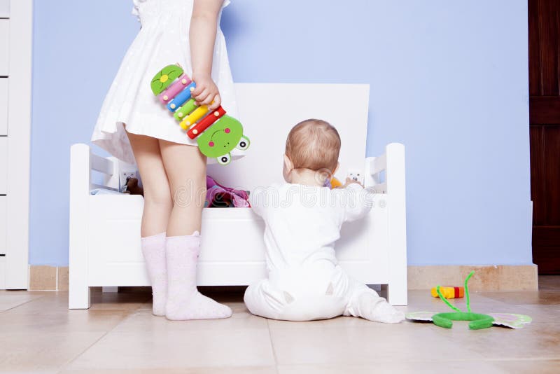 Bébé garçon jouant avec sa soeur à la pièce de jouets photos libres de droits Bébé garçon jouant avec sa soeur à la pièce de jouets photos libres de droits