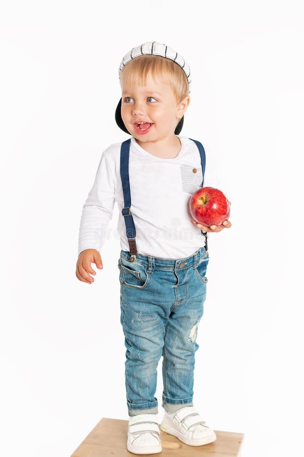 Bébé garçon mangeant la pomme et souriant dans le studio d'isolement sur le fond blanc photo stock Bébé garçon mangeant la pomme et souriant dans le studio d'isolement sur le fond blanc photo stock