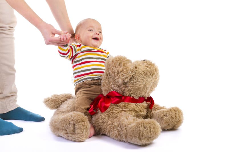 Bébé garçon sur le chien de peluche sur le blanc images libres de droits Bébé garçon sur le chien de peluche sur le blanc images libres de droits