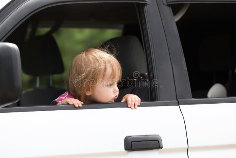 Bébé gauche seulement dans une voiture Parents de attente image stock Bébé gauche seulement dans une voiture Parents de attente image stock