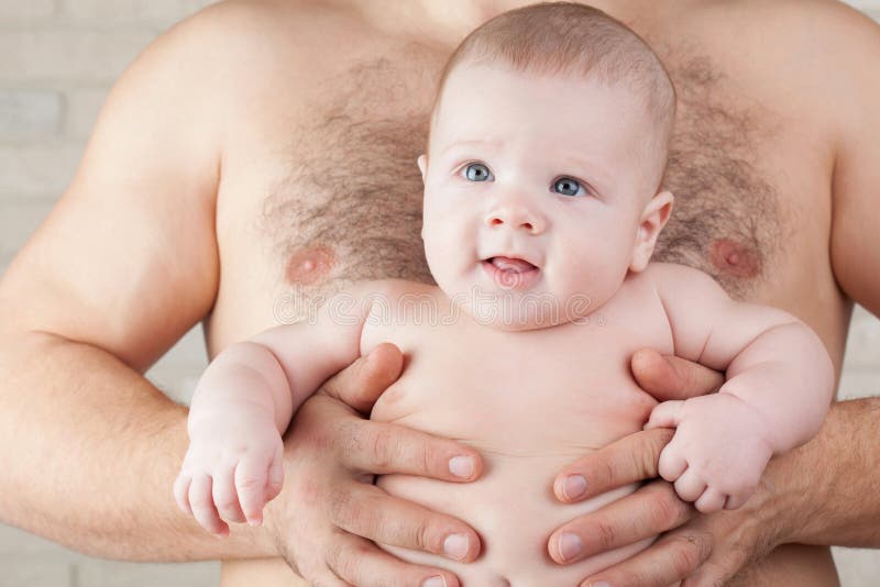 Bébé sur les mains fortes de son père photographie stock Bébé sur les mains fortes de son père photographie stock