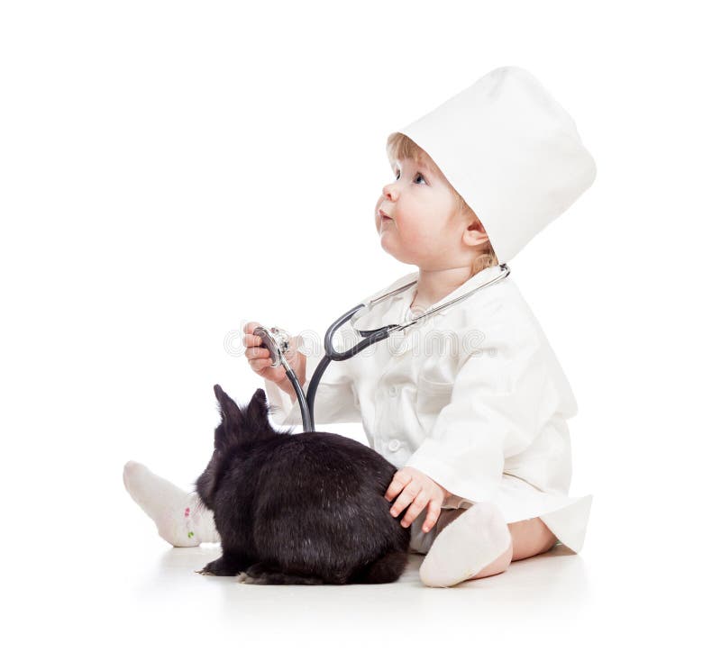 Bébé jouant le docteur avec le lapin d'animal familier photographie stock Bébé jouant le docteur avec le lapin d'animal familier photographie stock