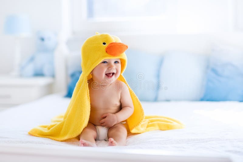 Bébé mignon après bain en serviette jaune de canard