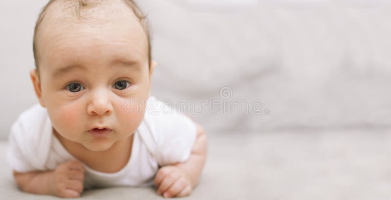 Bébé mignon sur son ventre, copyspace photographie stock libre de droits Bébé mignon sur son ventre, copyspace photographie stock libre de droits