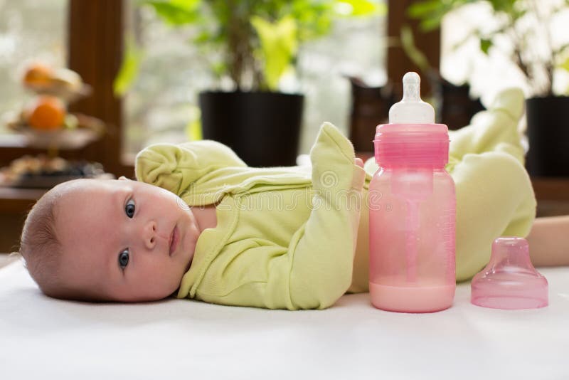 Bébé nouveau-né avec une bouteille de lait. image libre de droits
