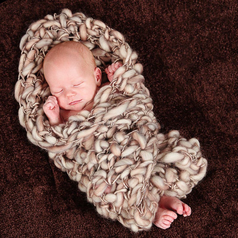 Closeup of newborn baby boy wrapped in rope-like blanket. Closeup of newborn baby boy wrapped in rope-like blanket.