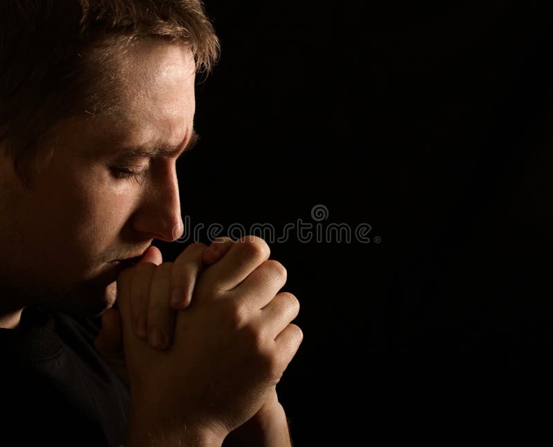Prayer. young man on black background. Prayer. young man on black background
