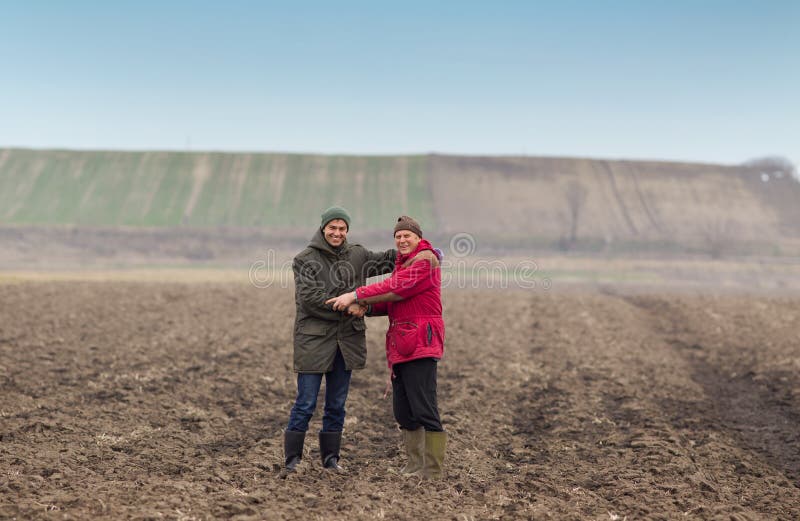 Two men shaking hands on farmland in winter time. Two men shaking hands on farmland in winter time