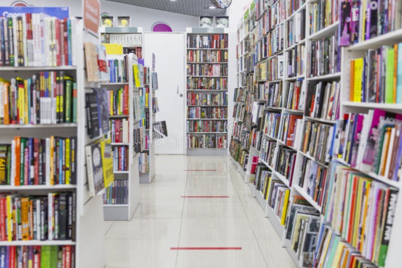 Bücher auf Regalen in einem Geschäft. ein großes Sortiment Literatur. verschwommen. Kennzeichnung auf dem Boden, während des Kunde lizenzfreie stockbilder