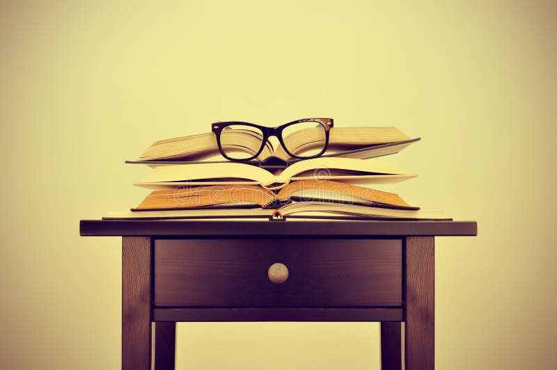 Bücher und Brillen auf einem Schreibtisch, mit einem Retro- Effekt lizenzfreie stockfotos Bücher und Brillen auf einem Schreibtisch, mit einem Retro- Effekt lizenzfreie stockfotos