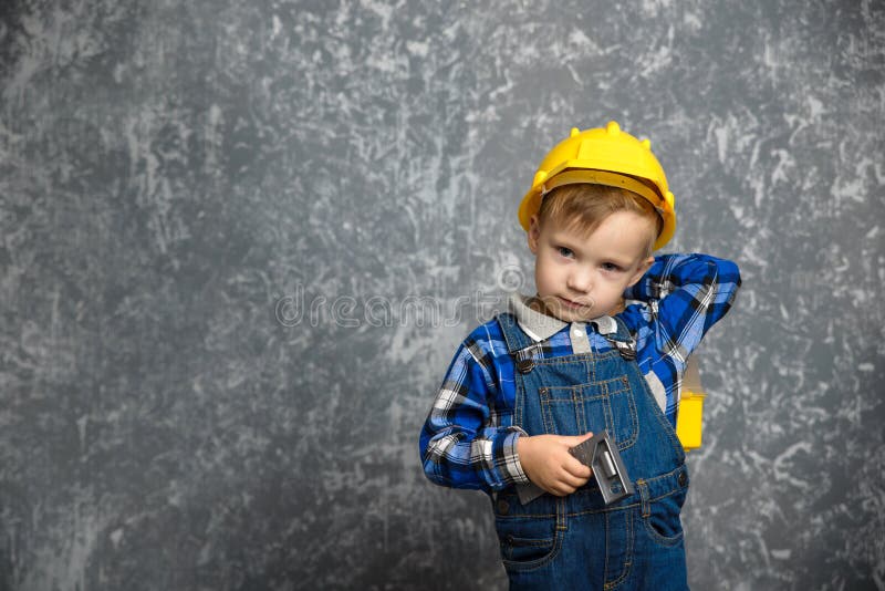 Băiat cu pălărie tare cu linie de construcție și cutie cu scule. Un băiat îmbrăcat într-o cămașă albastră cu o pălărie tare, cu o linie de construcție și o cutie cu scule