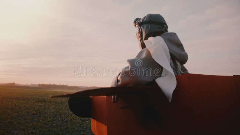 Băiat pilot fericit și serios, într-un costum de pilot de bord amuzant, uitându-se la o cameră care fuge în afara mișcării lente.. stock video footage