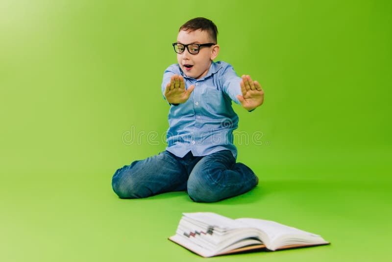 Băiatul cu cămașă albastră nu vrea să citească cartea. copilul nu învață lecții. nu apreciază cunoștințele. studio stock photography