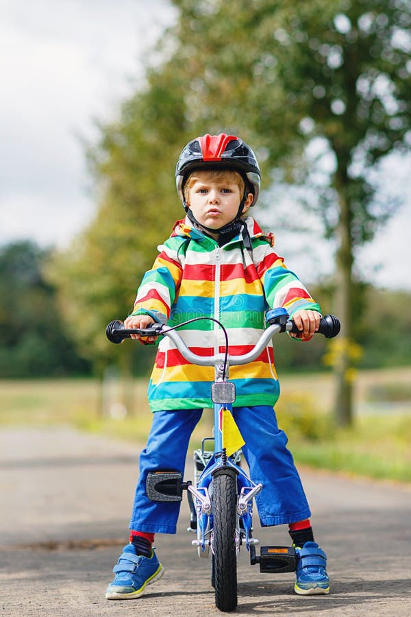 Băiețel drăguț pe bicicletă în ziua de vară sau de toamnă. . stock images