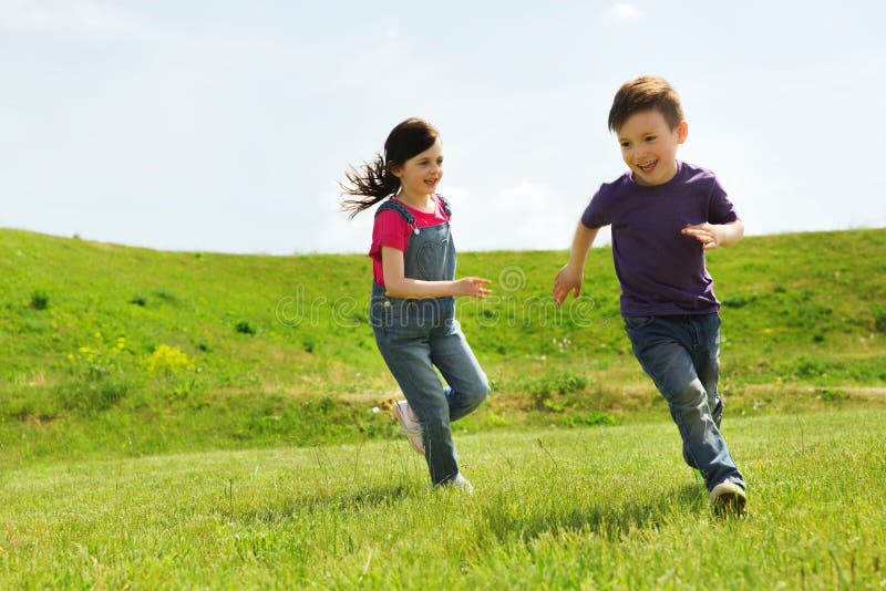 Băiețel fericit și fată care aleargă afară stock images
