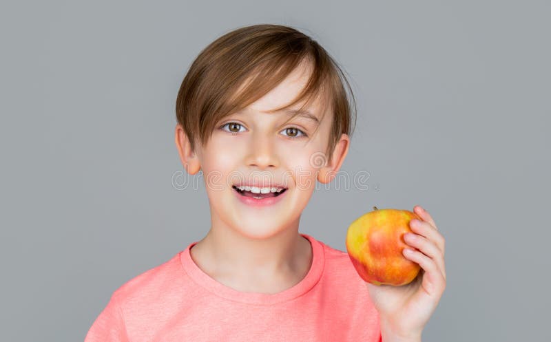 Băiețel mâncând mere și zâmbind. băiatul zâmbește și are dinți albi sănătoși. băiețel mâncând mere. mere de băiat stock image